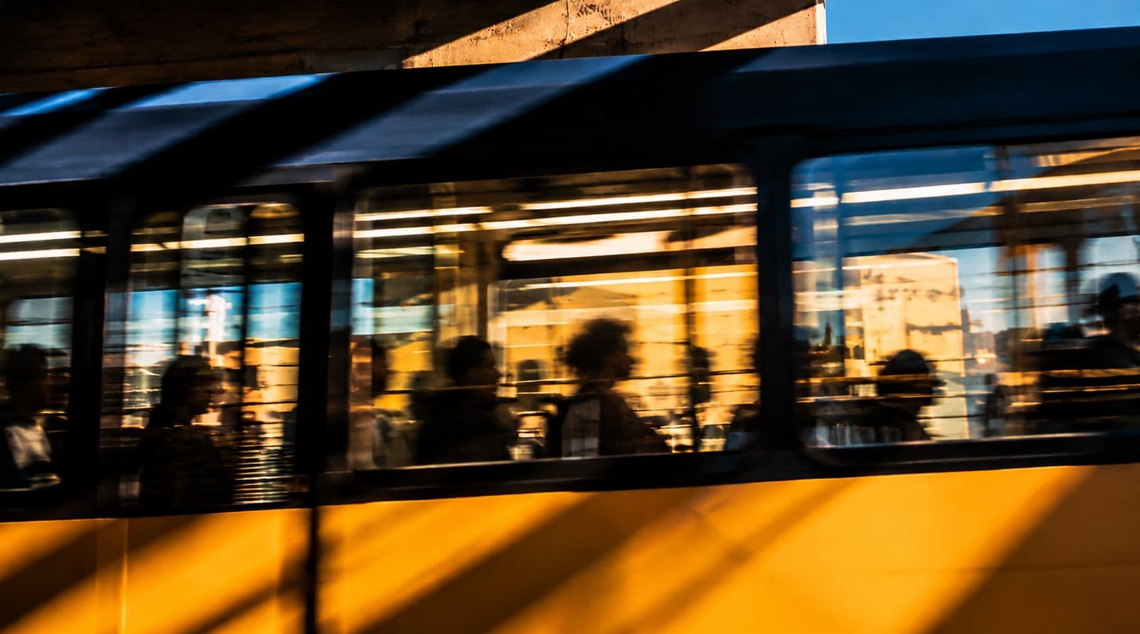 Passageiros dentro de um bonde ao entardecer